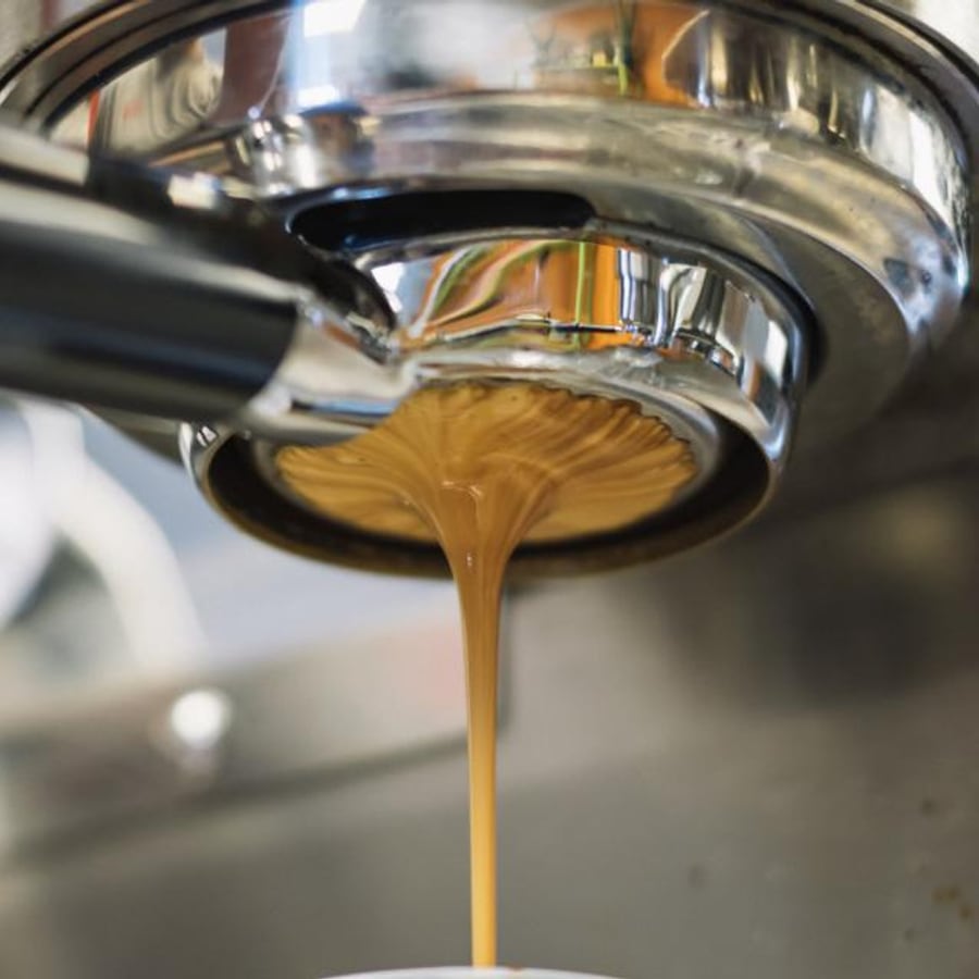 Espresso loopt uit de zeefdrager van een espressomachine
